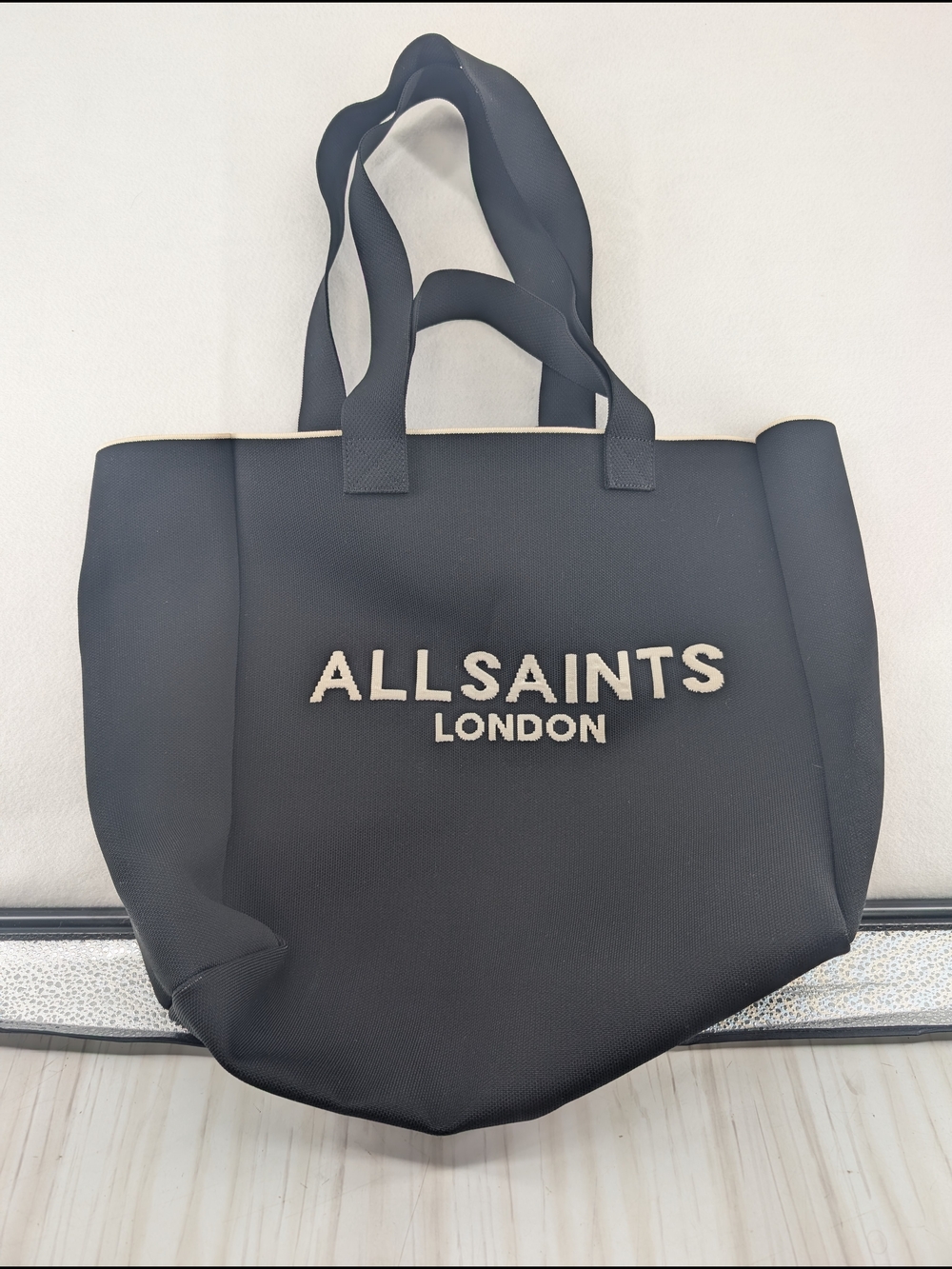 AllSaints Izzy Logo Knitted Tote Bag in black with contrasting cream letters